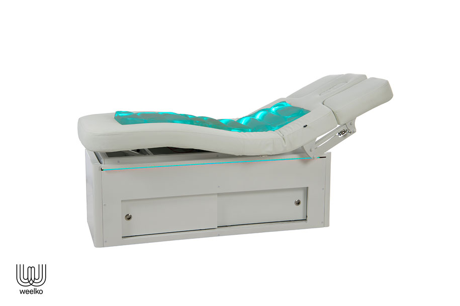 Weiße Massageliege flow, aufgerichtet, dick gepolstert, mit grünem LED Licht