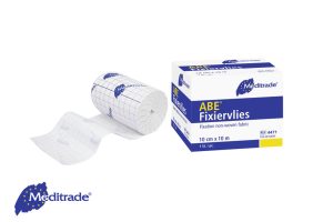 Meditrade ABE® Fixiervlies - selbstklebend in der Verpackung, daneben eine Rolle Fixiervlies abgewickelt